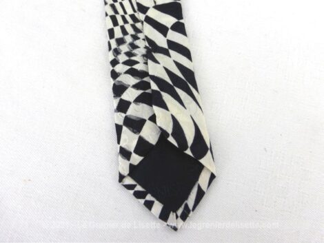 Voici une superbe cravate vintage, 100% soie, décorée de motifs psychédéliques noir et blanc, et de la marque Carnaval de Venise.