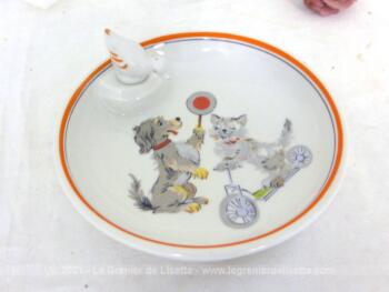 Adorable assiette chauffante pour bébé en porcelaine F.D. Chauvigny avec des dessins vintages d'un chien et d'un chat, et son bouchon en forme de canard.