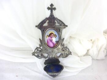 Voici un ancien bénitier en laiton, tout ciselé et ouvragé avec comme décoration un petit écusson représentant le Christ enfant portant une croix.