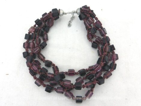 Sur 38 cm de long (+ chainette), voici un collier ras de cou très cour sur 4 rangs et avec des perles de verre carrées parme reliées entre elles par un subtil assemblage de fils épais.