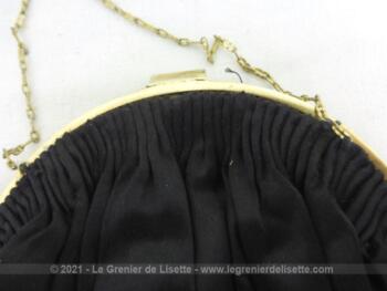 Belle minaudière, en satin noir avec un système de fermeture en laiton et petite chaine fine dorée. Elle n'est pas très ancienne mais elle en a tout le look.