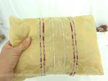 Voici un coussin fait main, habillé en tissus d'ameublement en brocart épais, sur fond ocre et liseré bordeaux décoré d’arabesques en relief.