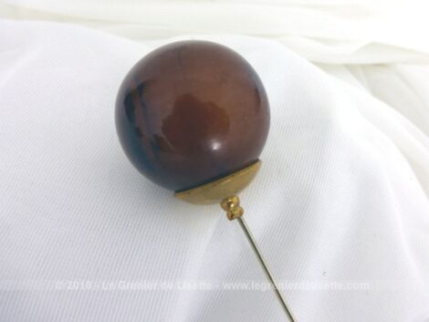 Sur 12.5 cm de long, voici une épingle à chapeaux avec une très grosse perle de verre de 3 cm de diamètre aux décors d'ambre.