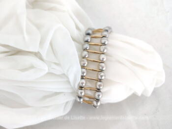 Superbe bracelet décoré de fausses perles sur les cotés, le tout entrecoupé par des dorures horizontales.