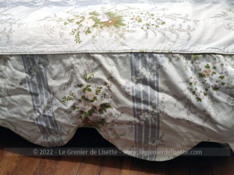 Adorable couvre lit de 190 x 135 cm sur fond ivoire décoré de larges bandes grises et de bouquets tendance shabby et ses 33 cm de volant plat en vague tout autour.