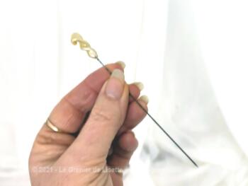 Épingle à chapeaux perle nacrée forme flamme, courte mais bien acérée, elle mesure 9.5 cm et se compose d'une longue perle de verre couleur ivoire nacrée.