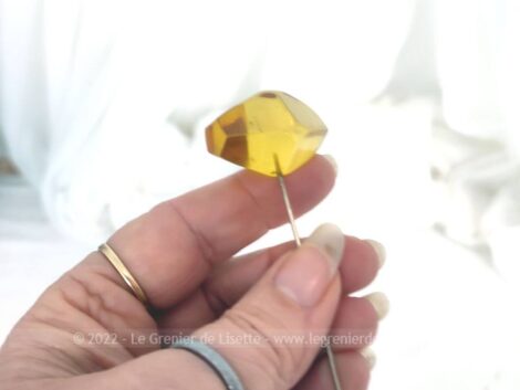 Sur 12 cm de long, voici un épingle à chapeaux dont le décor en bakélite couleur ambre représente une forme double hexagonale et conique.