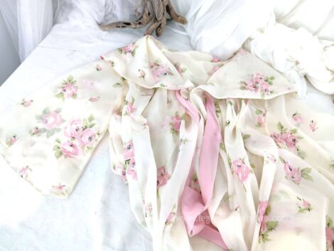 Voici un superbe peignoir vintage en nylon aux larges plis dans le dos et son grand col de la marque TORPEDO avec petites fleurs roses sur fond blanc cassé. Taille 38/40/42.