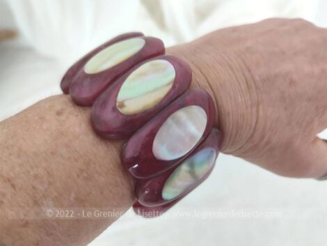 Voici un superbe bracelet couleur framboise réalisé un assemblage de larges perles plates en plastique vintage décorées de médaillon en nacre.