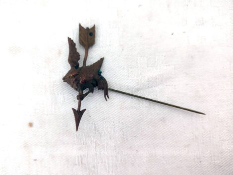 Sur 8 cm de long, voici une ancienne épingle à chapeaux composée d'un décor en laiton formant un oiseau accroché sur une flèche. Trop vintage !