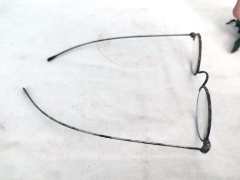 En métal, voici une paire d'anciennes lunettes à fines branches avec des verres pour voir de près et rangée dans un étui étroit en cuir