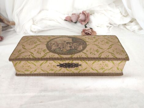 Voici une très ancienne boite habillée de tissus, galon avec en décoration un écusson cartonné représentant une scène galante du XVII° cerné de galon.