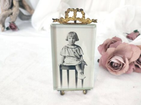 Ancien porte photo en laiton aux décors ouvragés et son verre biseauté avec une photo d'une fillette assise. Pièce unique et superbe du début du XX° !
