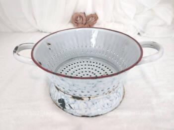 Sur 22 cm de diamètre, voici une ancienne passoire en métal émaillée en bleu moucheté avec anse et son socle intégré.