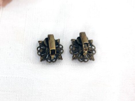 Superbe paire de boucles d'oreilles vintage à pince, avec une forme carrée créée par des volutes en métal qui sertissent des strass.