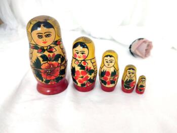 Voici un ancien jeu de 5 poupées Russes au châle jaune tenant un hibiscus dans les bras.