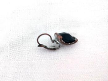 Voici une paire de boucles d'oreilles pour oreilles percées vraiment originales avec comme décor une perle noire à facettes.