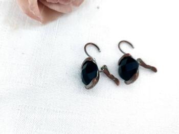 Voici une paire de boucles d'oreilles pour oreilles percées vraiment originales avec comme décor une perle noire à facettes.