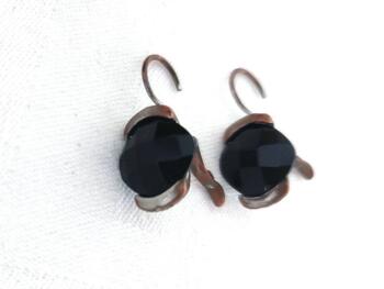 Voici une paire de boucles d'oreilles pour oreilles percées vraiment originales avec comme décor une perle noire à facettes.