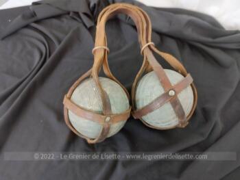 Totalement vintages, voici un paire boules de pétanque lyonnaises de 11 cm de diamètre et 1.1 kg chacune avec leurs lanières de transport en cuir.