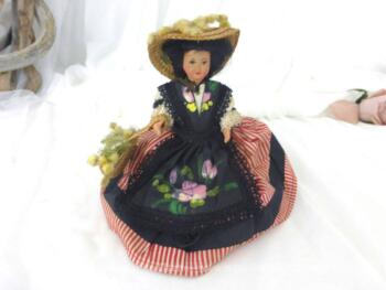 Ancienne poupée folklorique régionale "La Nicoise" au visage peint avec costume traditionnel, son grand chapeau et son sac rempli de mimosas.