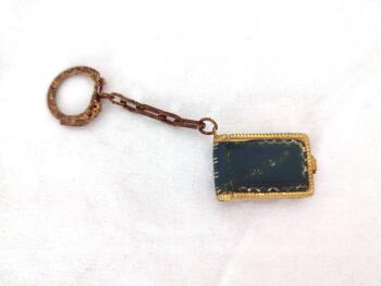 Voici un ancien porte clefs avec un petit livre de 3.5 x 2.2 cm à la reliure en cuir gravé du mot Bretagne et contenant un dépliant avec 10 photos .