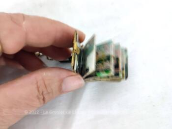 Voici un ancien porte clefs avec un petit livre de 3.5 x 2.2 cm à la reliure en cuir gravé du mot Bretagne et contenant un dépliant avec 10 photos .