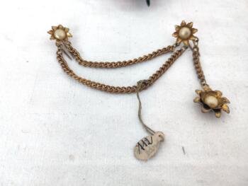 Vraiment originale et vintage, voici une chaine de fermeture de veste avec ses deux fleurs aux crochets et sa pendeloque.