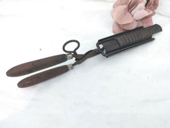 Ancien fer à friser les cheveux en métal composé de deux manches pour une prise en main avec pour la partie utilisée pour onduler ou cranter cranter,  une fourche plus un cylindre et une gouttière à stries coulissante avec une manette.
