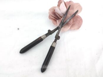Voici un ancien petit fer à friser portable et pliable en métal  avec ses deux manches en bois, un cylindre et une gouttière, pour bonne une prise en main.