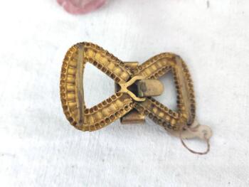 Retrouvée dans un stock d'une ancienne mercerie, voici une boucle de ceinture en laiton représentant une belle ganse avec encore son étiquette et son prix en anciens Francs. Vintage comme on aime !