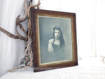 Sur 33 x 40 x 1.3 cm, voici un cadre en bois avec reliefs intérieurs dorés pour mettre en valeur une photo d'une jeune fille avec un noeud dans ses longs cheveux. A susprendre.