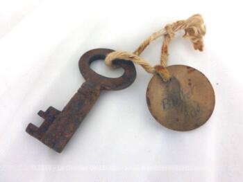 Voici un belle petite clef de buffet de 5  x 2.8 cm patinée par le temps et accompagnées par une vieille ficelle d'une plaque en carton portant l'inscription un peu effacée "Buffet bas".