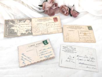 Datant du début des années 1900, voici cinq anciennes cartes postales représentant des fleurs habillées de strass pour certaines et d'autres aux contours décorés de paillettes .