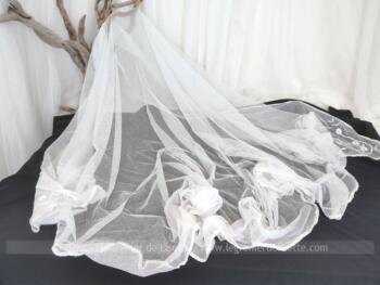 En forme de 1/2 lune de 200 cm de large jusqu'à 150 cm au plus long, voici un superbe voile de mariée ancien en tulle blanc avec deux fines broderies aux angles. Pour une décoration trop vintage.