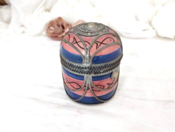 Datant des années 70, voici une ancienne boite marocaine ronde en céramique rose et bleue, habillée par de superbes décors en étain pour un effet shabby. Fait main, elle est estampillée 
