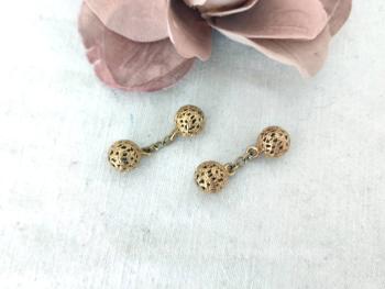 Pour femmes, voici une paire de beaux boutons de manchettes vintages en forme de sphères ciselées et ouvragées reliées entre elles par une chainette. Plaqué or et superbes !!!