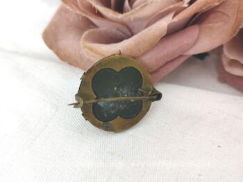 Voici une ancienne broche avec une médaille en fer blanc représentant l'apparition de la Vierge devant Bernadette dans la grotte de Lourdes, le tout sertie dans du laiton sur 1.5 cm de diamètre.