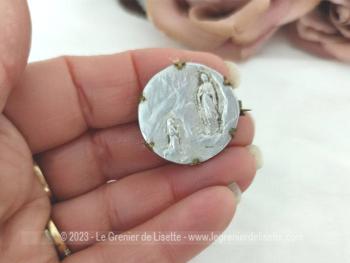 Voici une ancienne broche avec une médaille en fer blanc représentant l'apparition de la Vierge devant Bernadette dans la grotte de Lourdes, le tout sertie dans du laiton sur 1.5 cm de diamètre.
