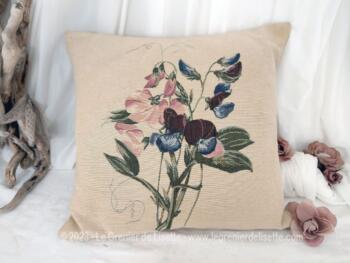 Voici une housse de coussin en toile fine de coton beige avec au centre un motif de fleurs dessinées dans la trame du tissus, comme une tapisserie.