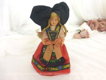 Voici une ancienne poupée régionale "L'Alsacienne"au visage peint à la main en costume traditionnel avec sa grande coiffe noire en forme de noeud.