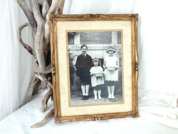 Sur 32 x 27 cm, voici un ancien cadre en bois ouvragé avec du plâtre et doré mettant en valeur une superbe photo  de trois enfants du début du siècle dernier.