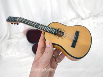Sur 26 cm de long, voici une belle guitare miniature en bois avec 6 fils de fer pour servir de cordes  et son étui  avec anse et fermoir. Pour une décoration originale !