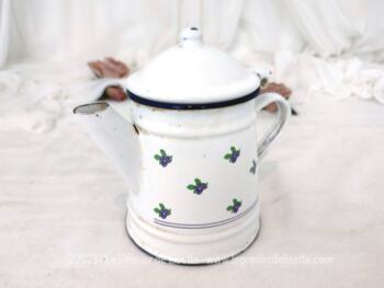 Voici une belle et ancienne petite cafetière émaillée en blanc et décorée de petites fleurs mauves, ancien jouet peut être mais avec une belle patine authentique d'éclat d'émail et d'oxydation. Pour une cuisine et décoration vintage !