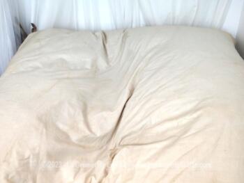 Ancien édredon presque carré de 140 x145 cm habillé de tissus en coton écru et garni de plumes et duvet, bien chaud .