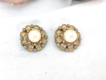 Voici une paire de boucles d'oreilles vintages à pince ornées par une mise en place originale de strass et dorures en étoile avec une grosse perle nacrée au centre  !