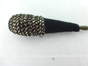 Ancienne épingle à chapeaux en forme de cône avec un double habillage en spirale, de la cordelette satinée noire en bas et sur l'autre partie un mélange de cordelette noire entremêlée d'un fin ruban en papier doré.