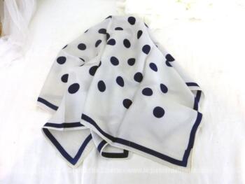 Sur 65 x 65 cm, voici un adorable foulard en tissus soyeux, aérien, en polyester,  avec des pois bleu marine sur un fond blanc légèrement cassé.