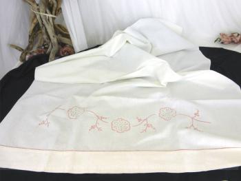 Voici une ancienne parure de berceau fait main, composée d'un drap et d'une taie d'oreiller arrondie  avec broderies roses et incrustation de dentelle.