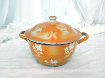 Ancien petit fait-tout émaillé en orange et décoré de fleurs, rempli d'authenticité avec ses éclats et ses marques du temps passé. Original.